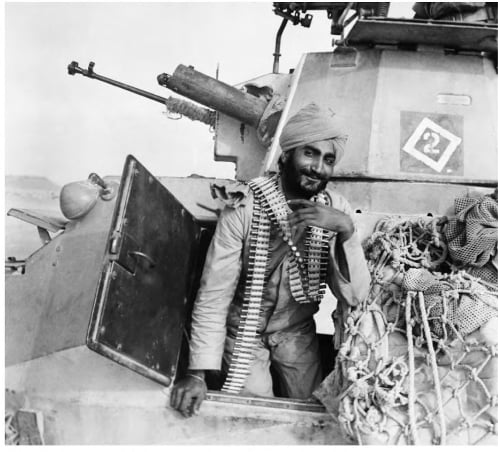 An Indian soldier of the Fourth Indian Division in a armoured vehicle with a bandolier around his neck in Egypt, 1941.