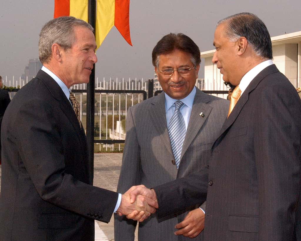 Pakistani Prime Minister Shaukat Aziz shakes hands with U.S. President George W. Bush at the presidential palace in Islamabad, on March 4, 2006 while Pakistani President General Pervez Musharraf, looks on. (Photographer: Muzammil Pasha/Bloomberg News)